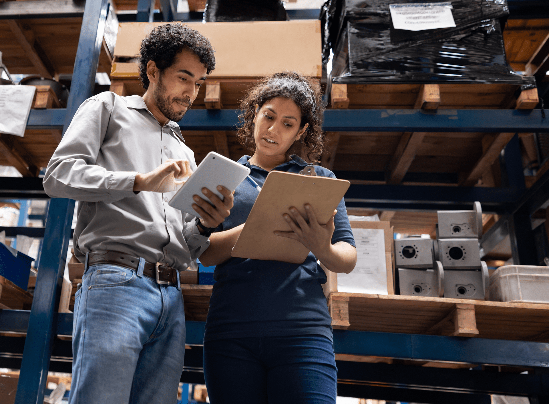 Warehouse workers discussing inventory on tablet